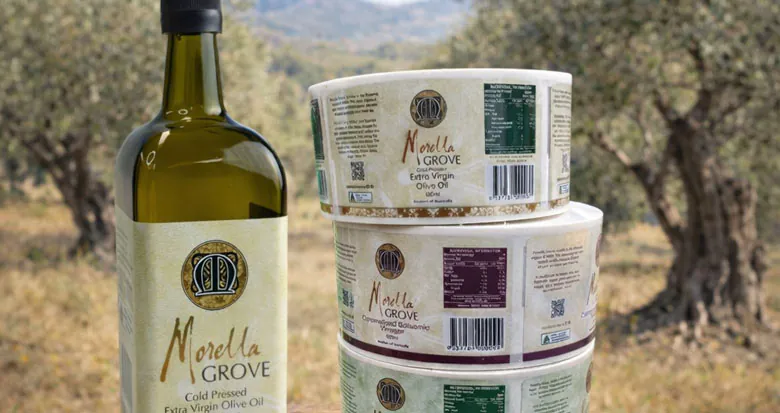 Morella Grove extra virgin olive oil bottle and gourmet olive products in an olive grove setting